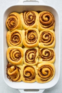 Baked orange rolls in a casserole dish.