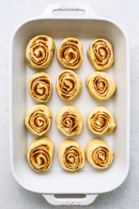 Sliced orange rolls in a casserole dish.