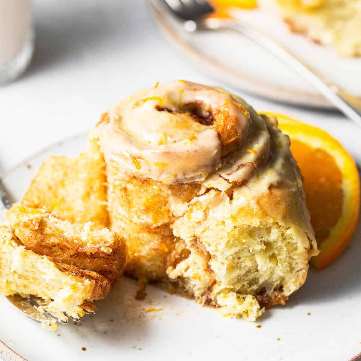 An orange roll with a bite taken out of it. 