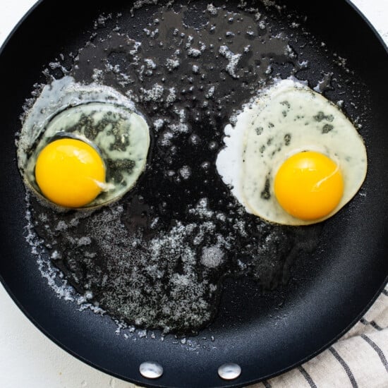 Two fried eggs in a frying pan.