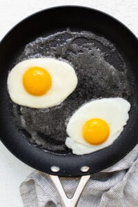 Two fried eggs in a frying pan.