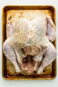 A roasted chicken on a baking sheet.