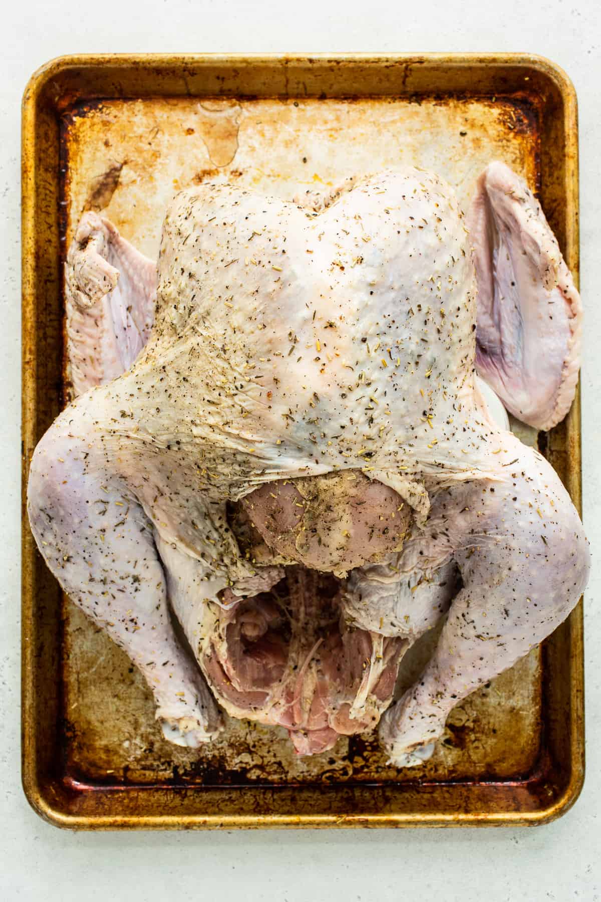 Raw turkey on a baking sheet.