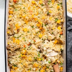Chicken and vegetable casserole in a baking dish with a wooden spoon.