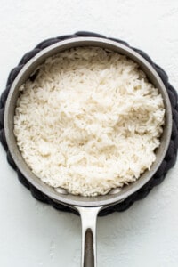 White rice in a pan on a white background.