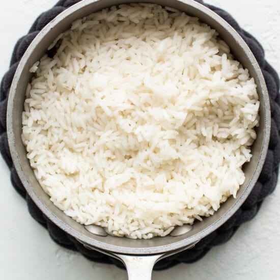 White rice in a pan on a white background.
