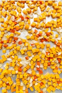 A pile of yellow and orange cubes on a baking sheet.