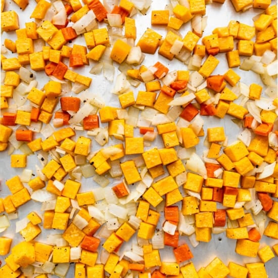 A pile of yellow and orange cubes on a baking sheet.