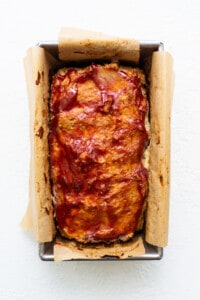 Meatloaf in a baking pan with bbq sauce.