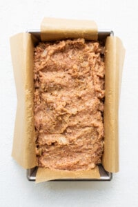 A loaf of bread in a pan on a white surface.