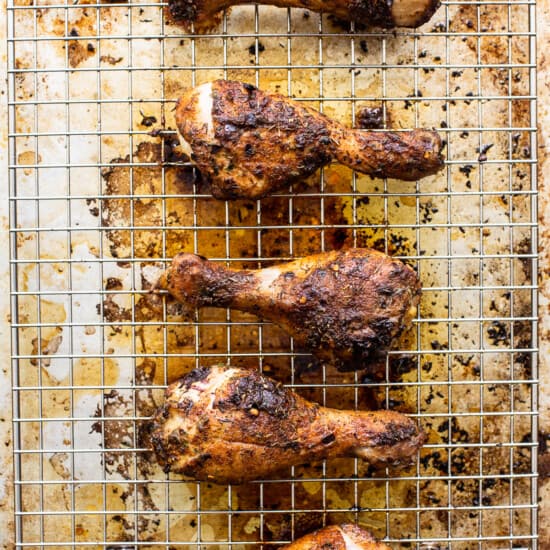 Roasted chicken legs on a cooling rack.