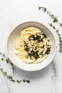 Butter, herbs and garlic in a bowl.