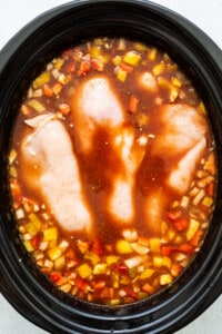 A crock pot filled with chicken and vegetables.