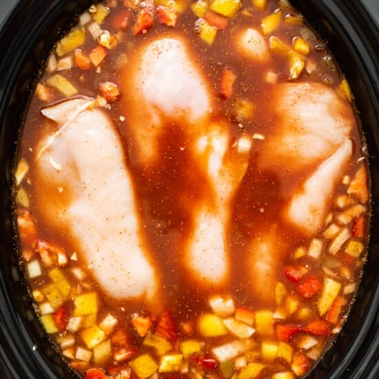 A crock pot filled with chicken and vegetables.