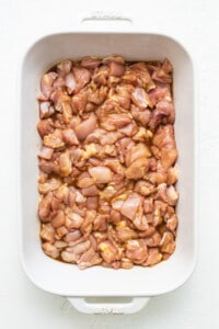 chicken marinating in casserole dish.