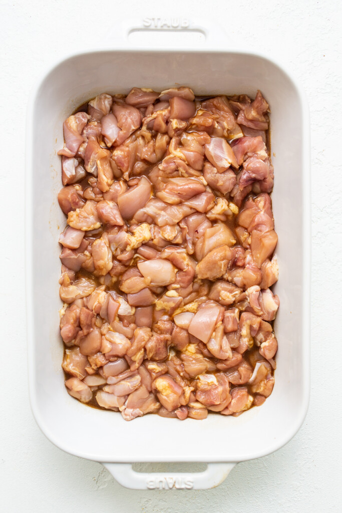 chicken marinating in casserole dish.