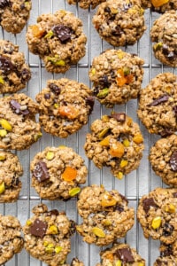 Oatmeal cookies with pistachios and nuts on a cooling rack.
