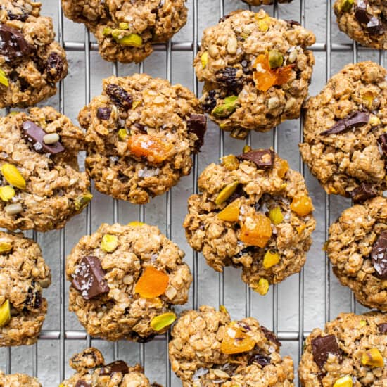 Oatmeal cookies with pistachios and nuts on a cooling rack.