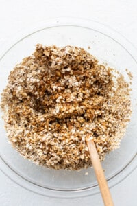 Oats in a bowl with a wooden spoon.