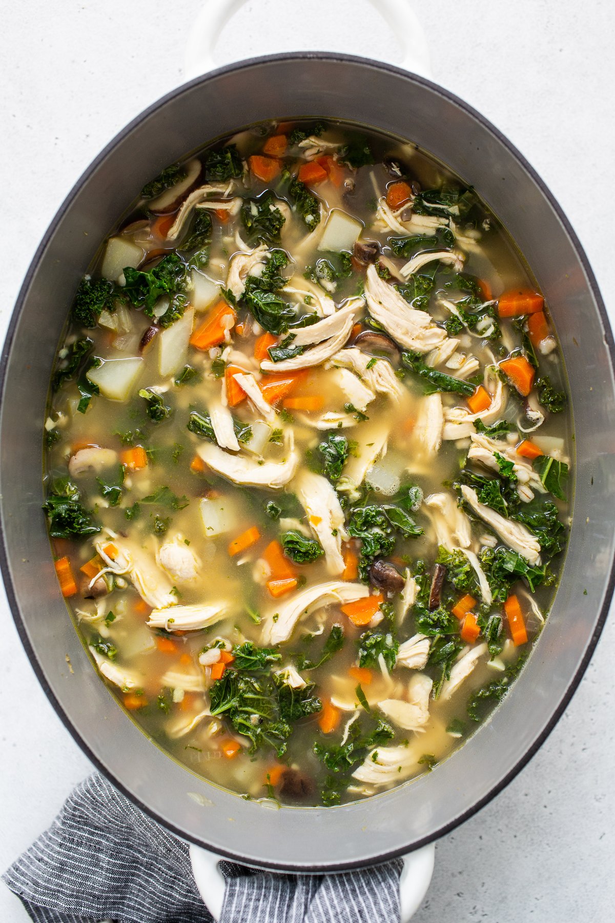 Chicken soup with shredded chicken and kale added in. 
