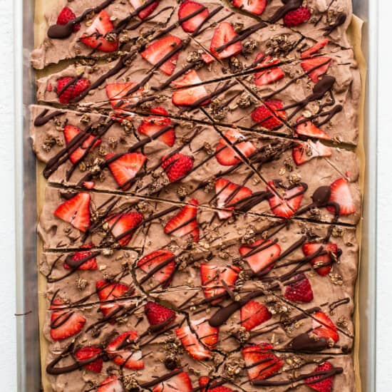 A sheet of chocolate covered strawberries on a baking sheet.