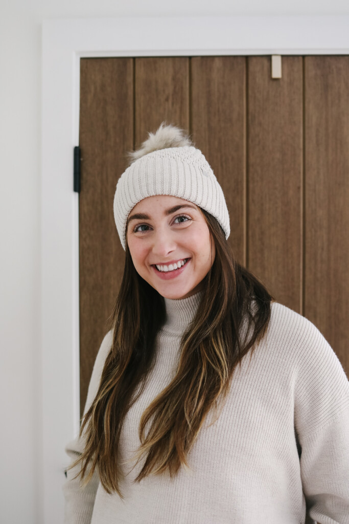 Woman wearing a beige beanie.