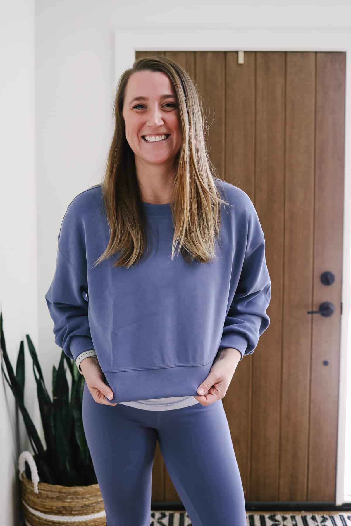 Woman wearing a periwinkle sweatshirt.