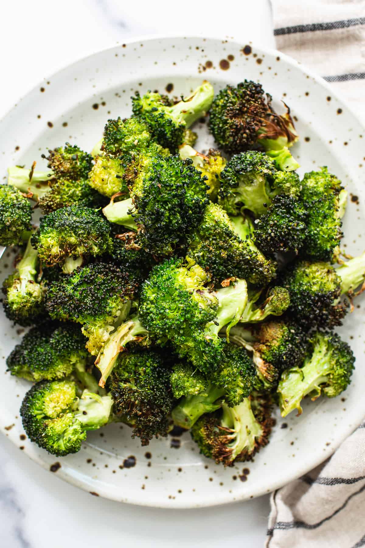 Air fryer broccoli på en tallrik.