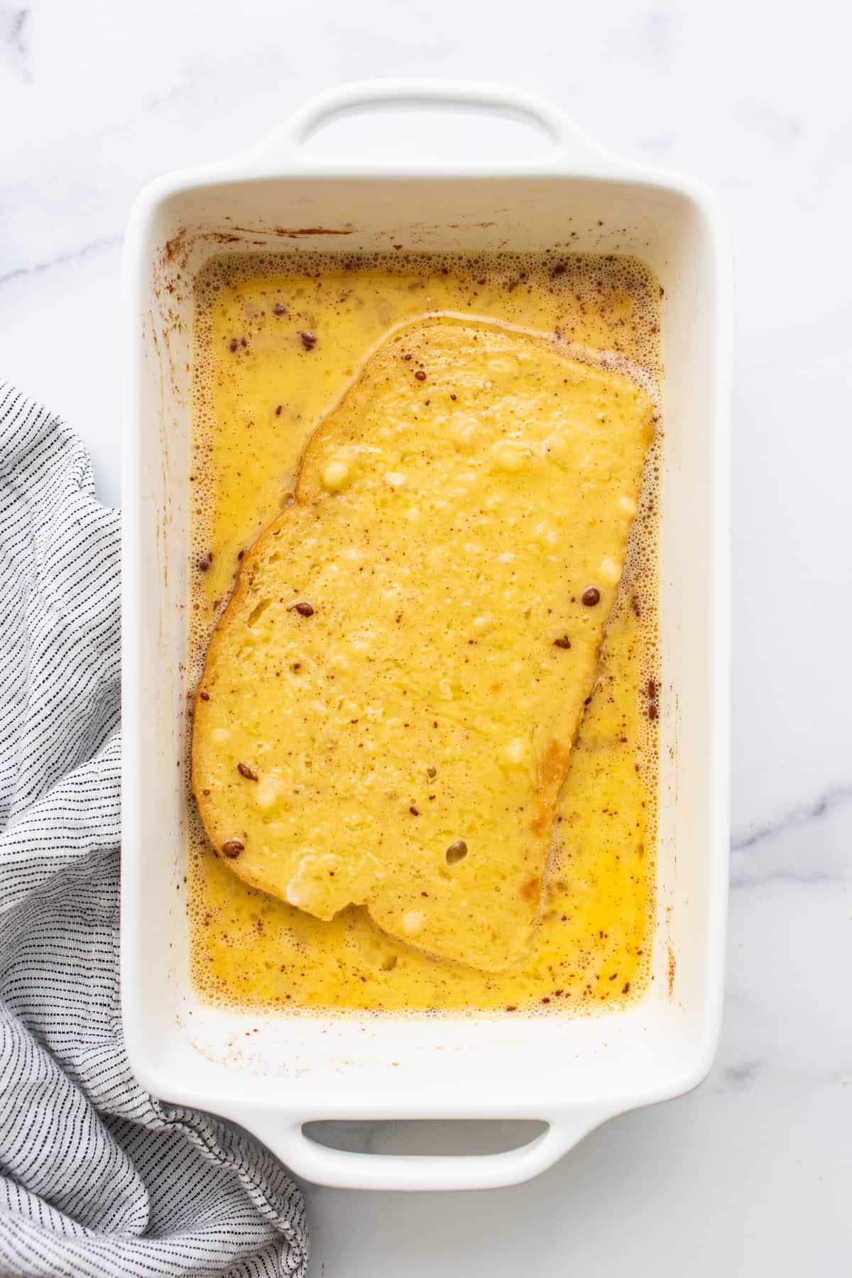 Air fryer french toast in an egg wash.