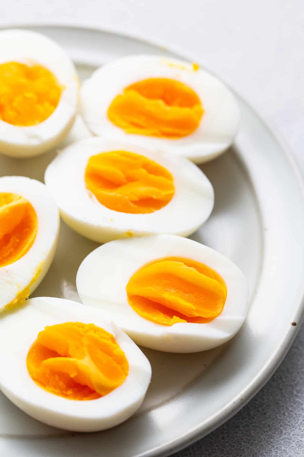 Heißluftfritteuse hart gekochte Eier auf einem Teller.