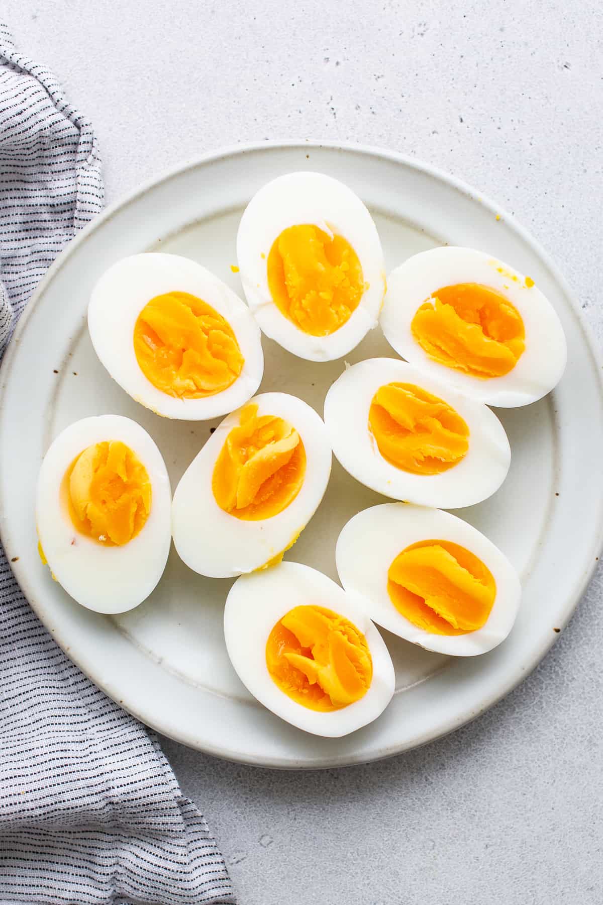 Hart gekochte Eier halbiert auf einem Teller.