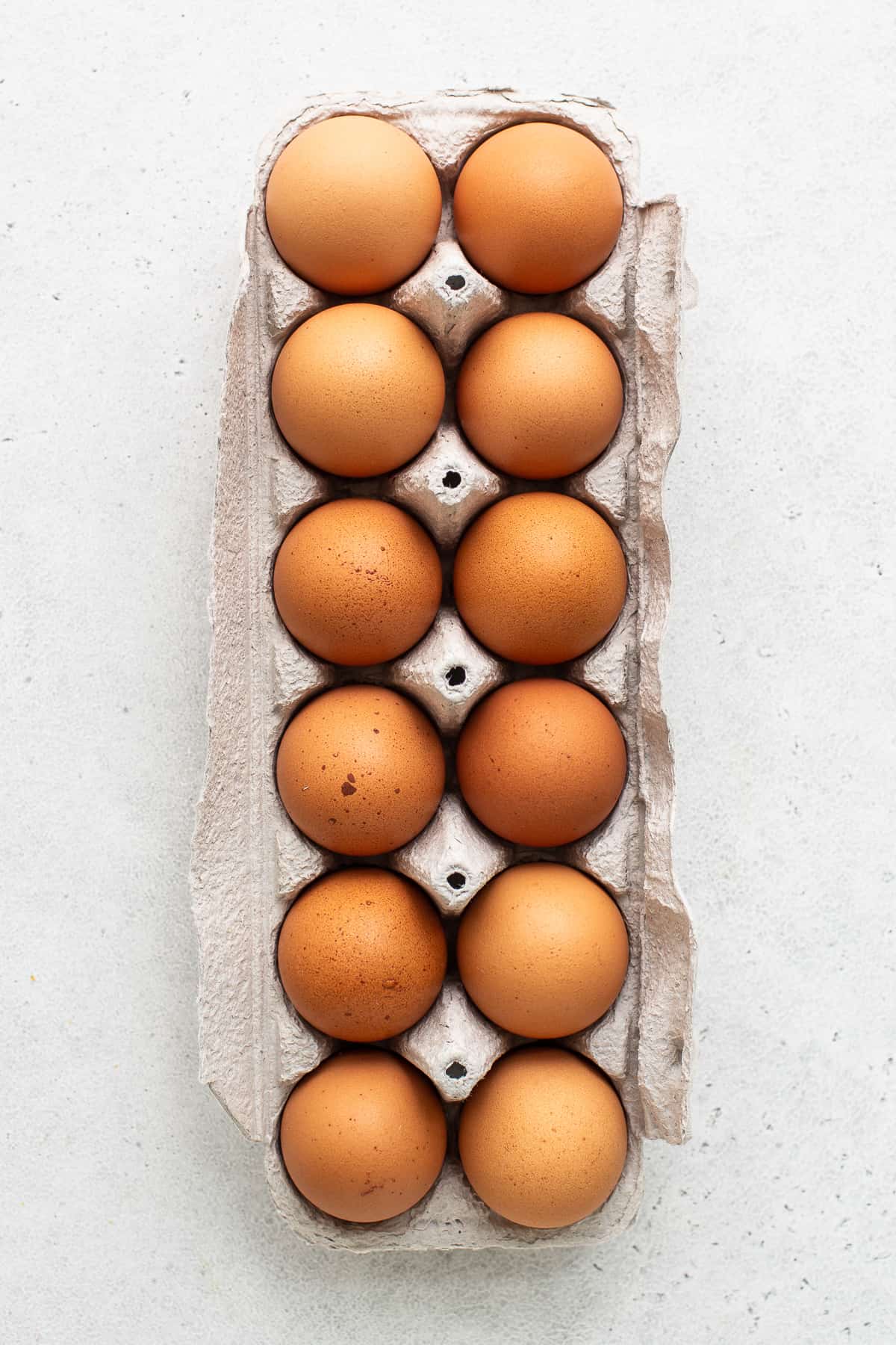 A dozen eggs in an egg carton.