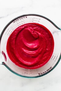 Beet puree in a measuring cup.