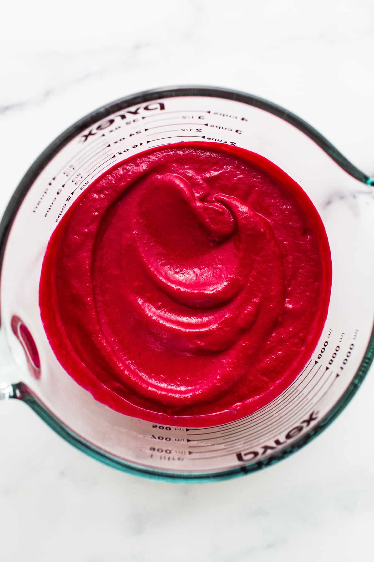 Blended beet sauce in a measuring bowl.