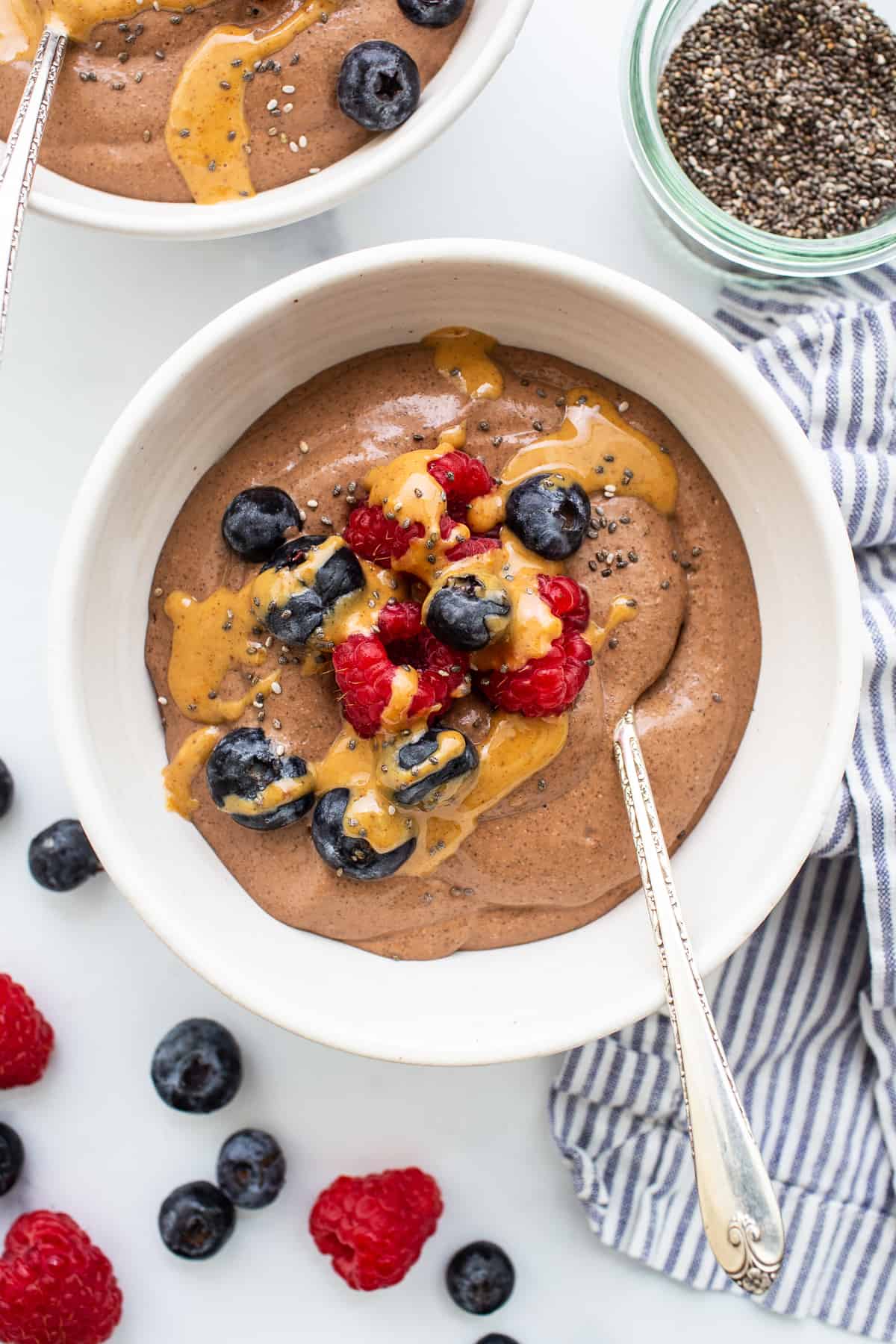 Blended chia seed pudding in a bowl topped with berries and peanut butter.