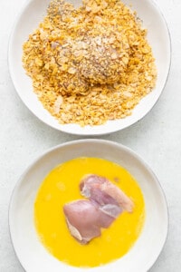 A bowl of granola and a bowl of orange juice.