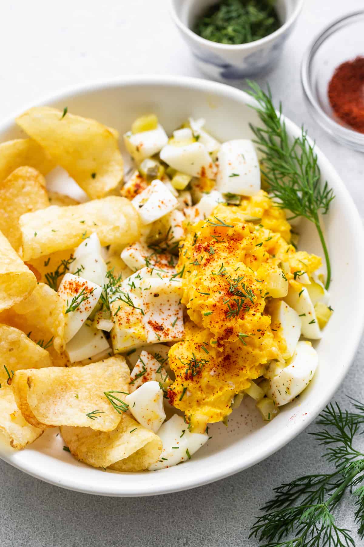 Deviled äggsallad i en skål med potatischips.