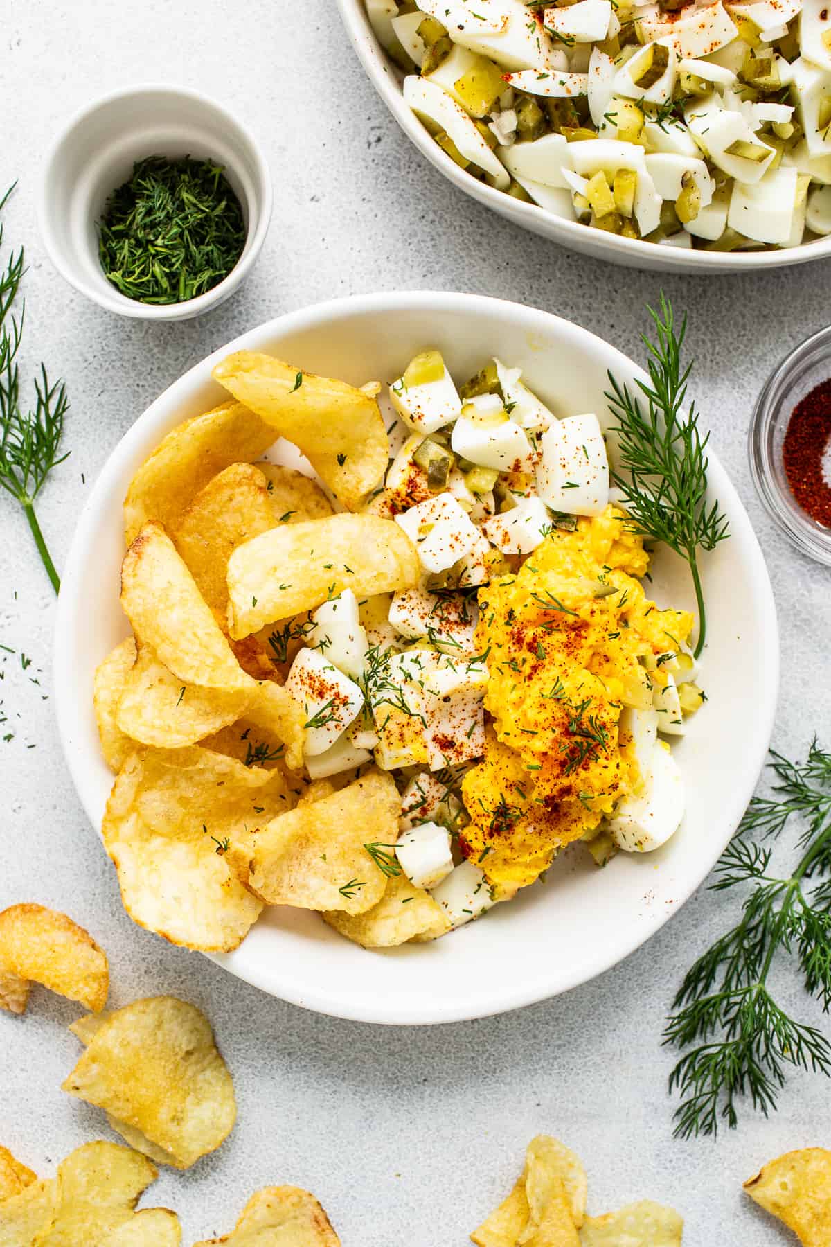 Deviled egg salad in a bowl with potato chips.