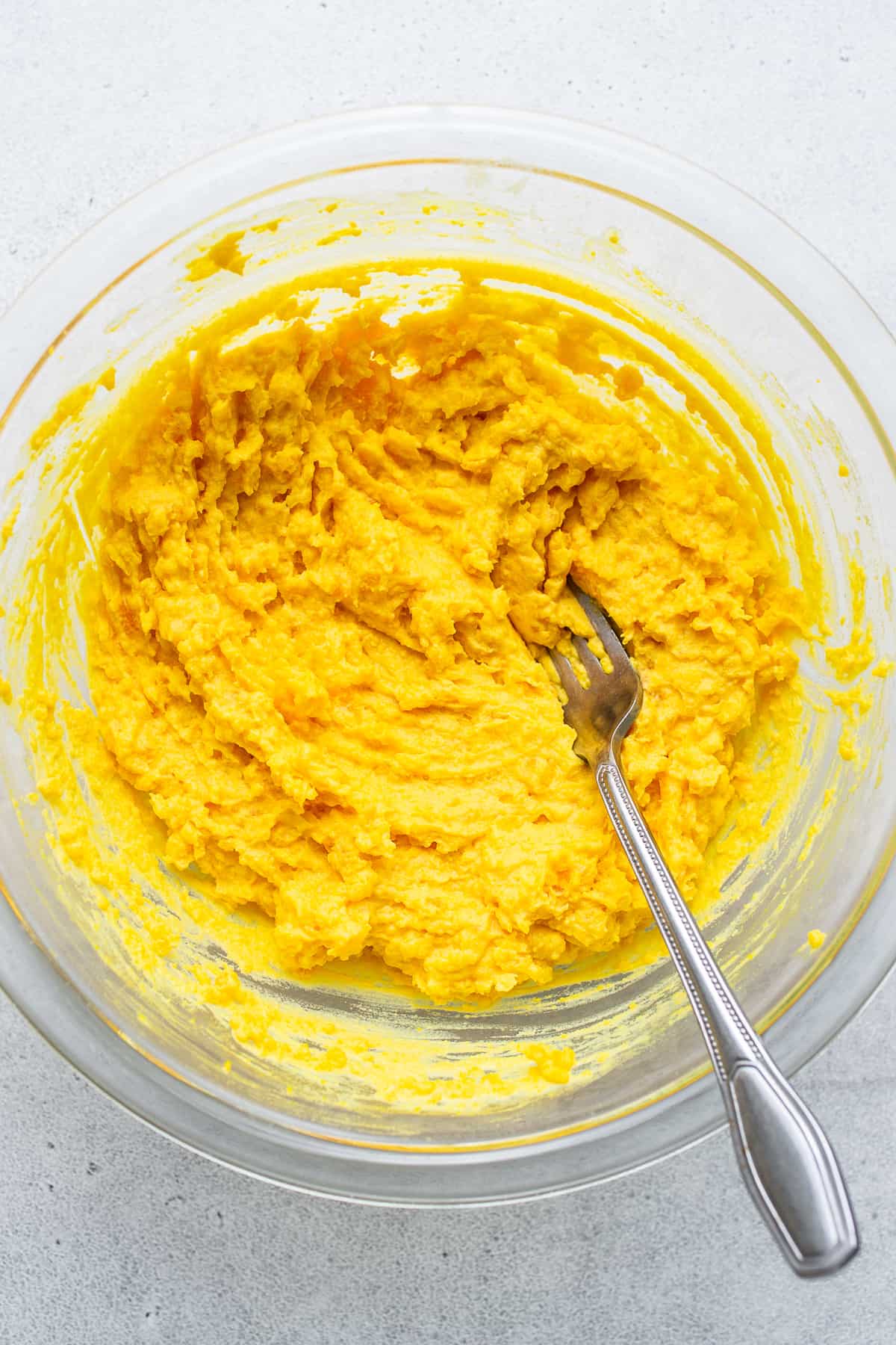 Egg yolks mixed in a bowl with a fork.