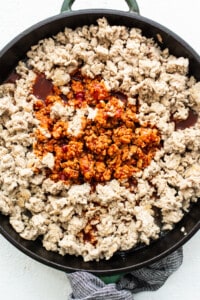 Ground chicken in a skillet.