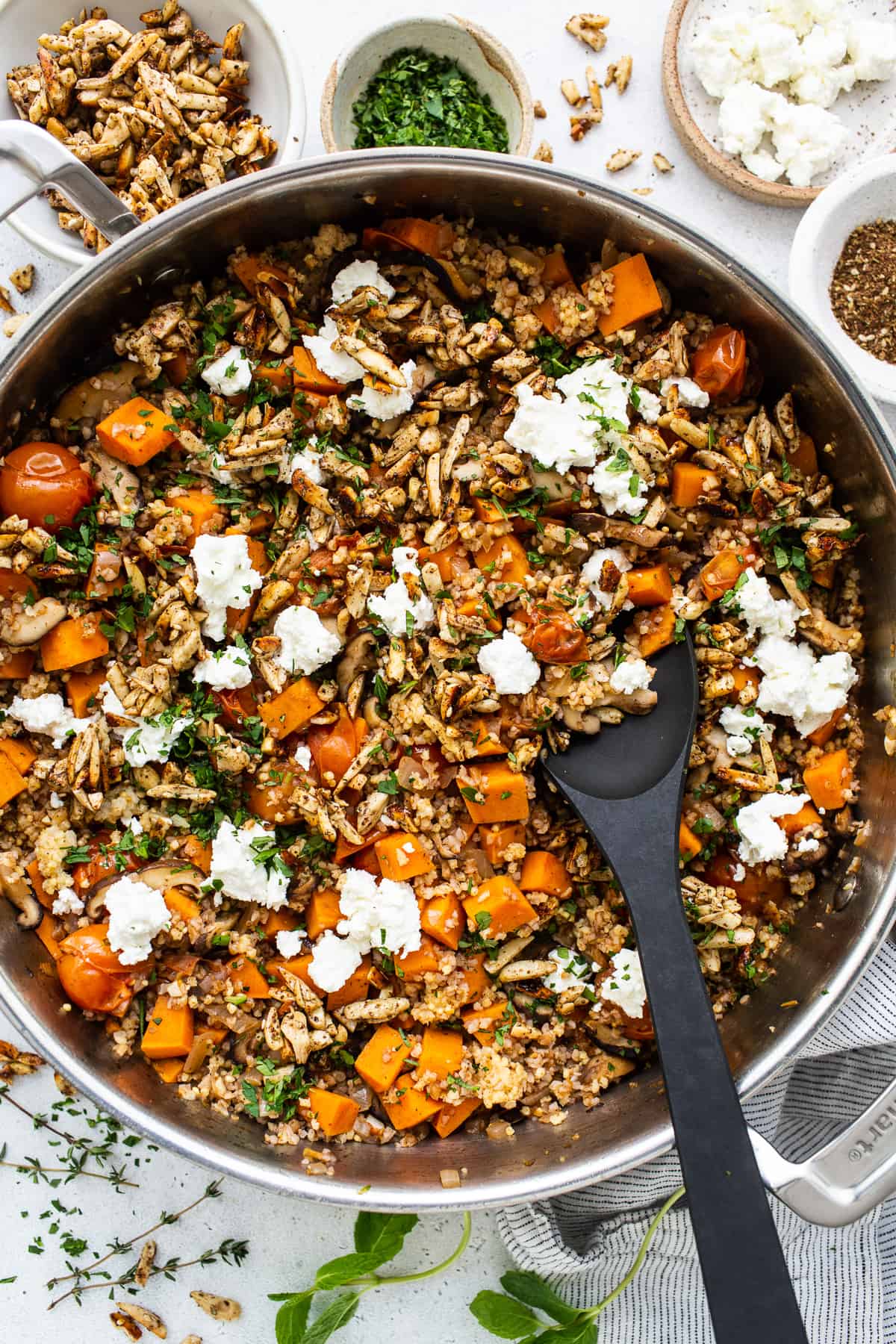 A skillet filled with vegetables and feta cheese.