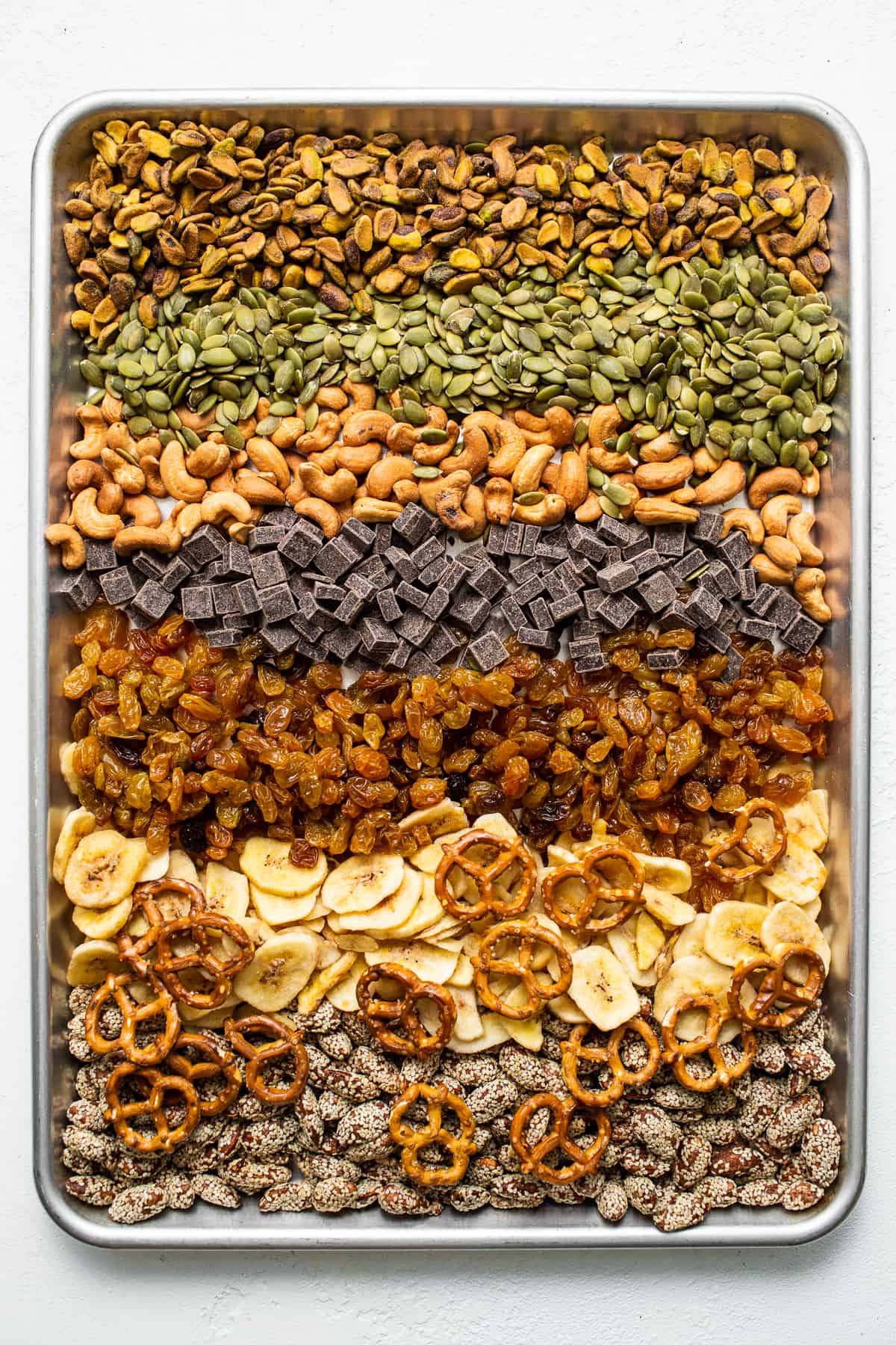 Homemade trail mix ingredients on a baking sheet.