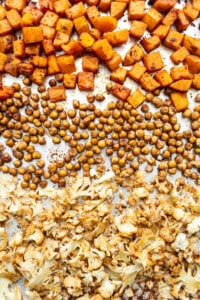 Butternut squash, chickpeas, and cauliflower on a baking sheet.