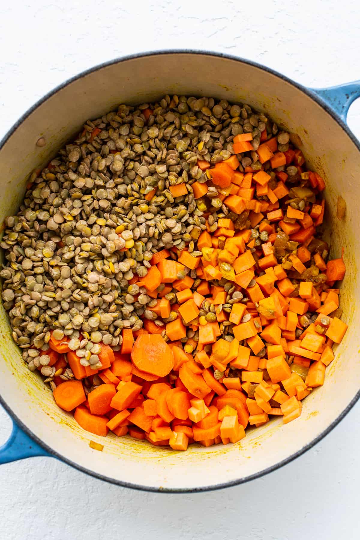 Diced sweet potatoes and lentils in a dutch oven.