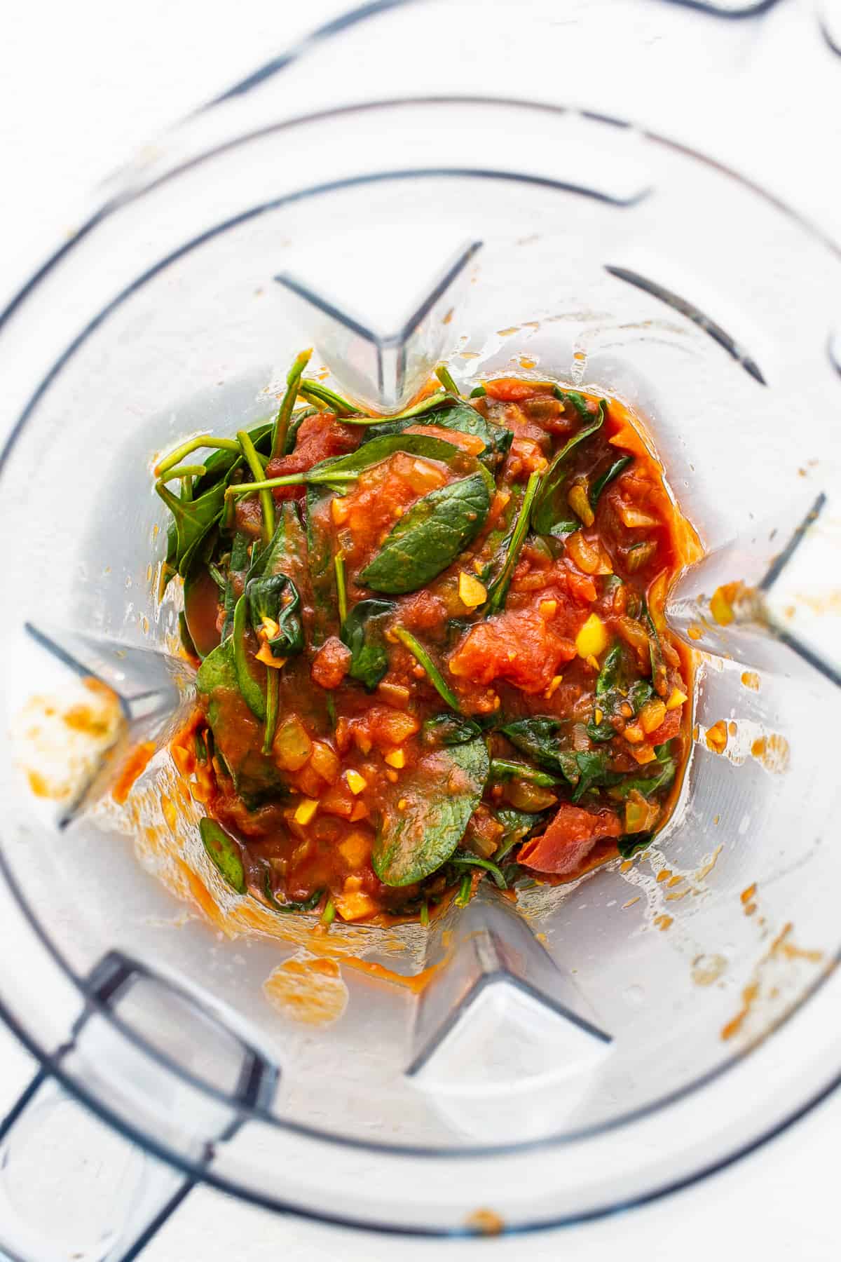 Spinach and tomato sauce in a blender.