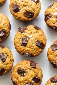 A group of chocolate chip muffins on a white surface.