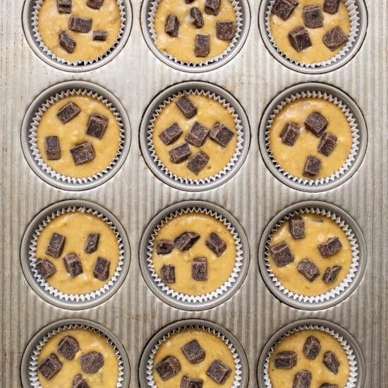 A muffin tin filled with chocolate chip muffins.