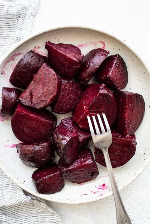 Sliced beets on a plate with a fork.
