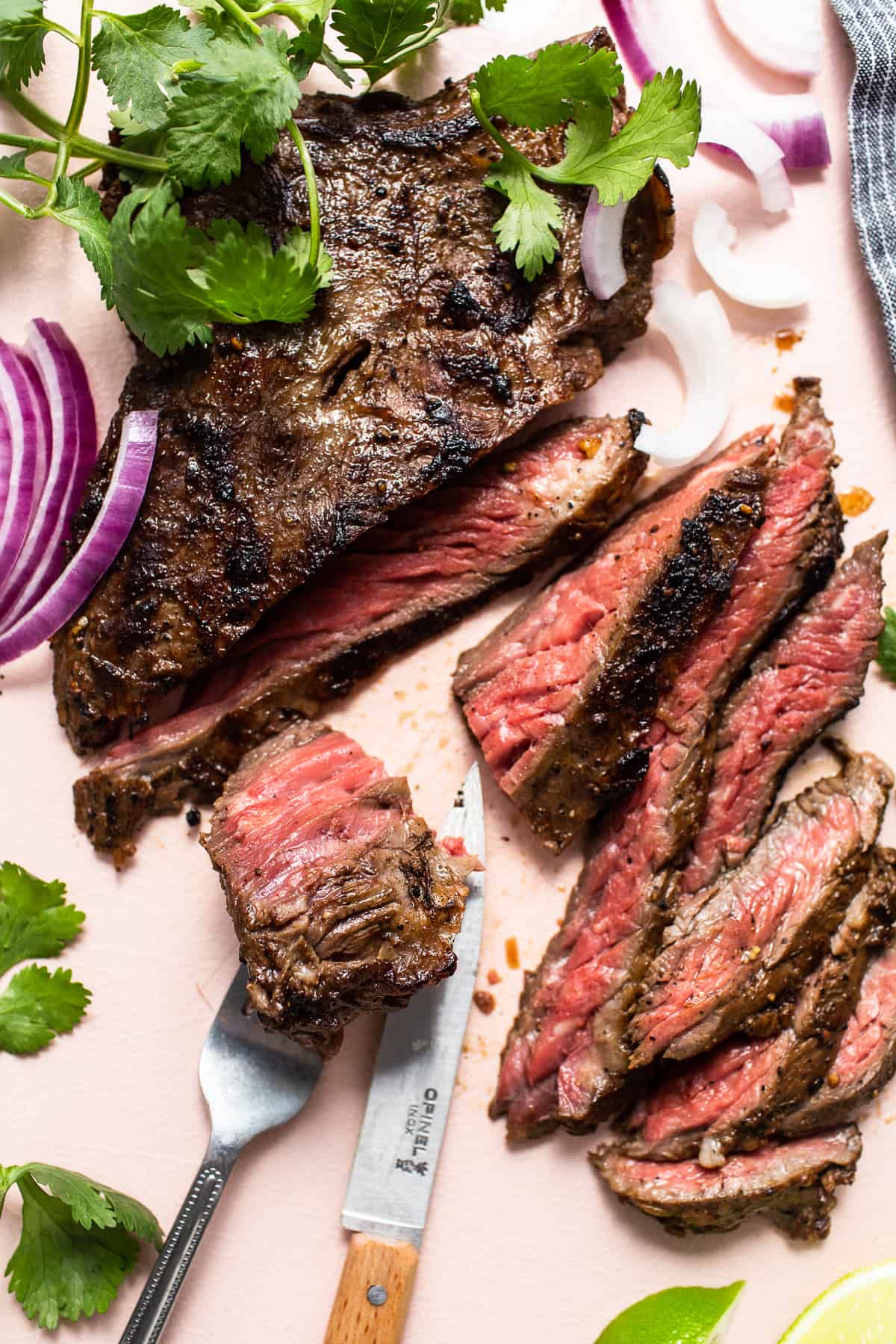 Sliced skirt steak being cut with a knife.