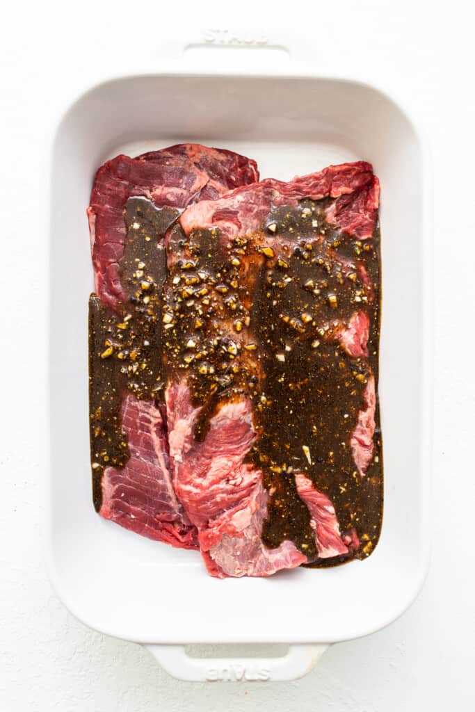 Skirt steak i ett fat toppat med marinad.